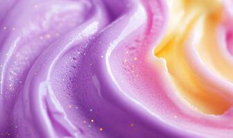 A swirl of purple, pink, and yellow frosting with glitter on top photo