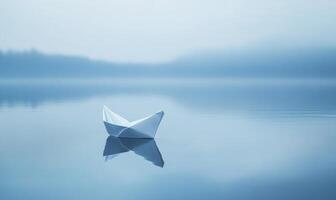 A paper boat sits in the water, reflecting the sky photo