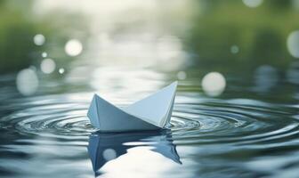 A paper boat is floating in a lake water photo