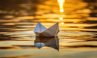 a paper boat floating in the water at sunset photo
