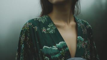 Close Up of a Woman Wearing a Green Kimono with Floral and Mountain Print. The image showcases the intricate details of the garment. photo