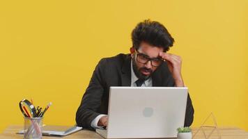 Indian businessman programmer software developer working on laptop loses becoming surprised by bad news results, fortune loss fail, computer virus at office. Deadline, bankruptcy. Freelancer young man video