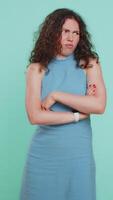 Offended sad nervous woman having misunderstanding, frustrated after quarrel, fail, lose, ignores and does not want to communicate, talk. Girl isolated on blue studio background. Lifestyles. Vertical video