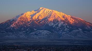 Majestic Sunset over a Snow-Capped Mountain Range. A breathtaking view of a dramatic alpine landscape at golden hour. photo