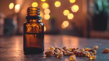 Amber Essential Oil in a Glass Bottle with Resin Pieces on a Wooden Table. photo