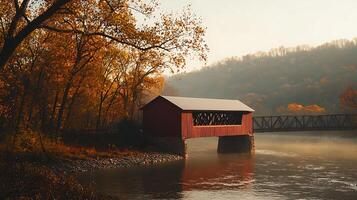 Autumnal Serenity A Red Covered Bridge Reflecting in a Misty River. photo