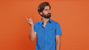 Displeased upset middle eastern man reacting to unpleasant awful idea, dissatisfied with bad quality, wave hand, shake head No dismiss idea dont like proposal. Guy isolated on orange studio background video