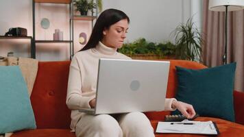 Woman accountant working with documents graph, calculate taxes for charts and graph reports of home income. Businesswoman working on laptop computer with financial bills planning expenses budget video