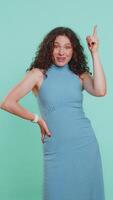 Eureka. Inspired adult woman pointing finger up with open mouth, having good idea plan startup, showing inspiration motivation gesture, problem solution. Girl isolated on blue background. Vertical video