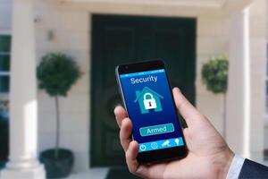 man controls smart home devices using app for mobile phone on background of the front door. concept of digitalization. a mockup with hand holding phone. photo