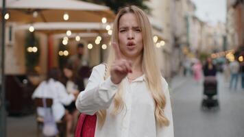 Displeased upset young woman reacting to unpleasant awful idea, dissatisfied with bad quality, wave hand, shake head No, dismiss idea, dont like proposal outdoors. Teenager girl walking in city street video