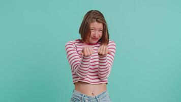 Need some more, please give me, help. Woman showing a little bit gesture with sceptic smile, showing minimum sign measuring small size. Pretty girl in crop top isolated alone on blue studio background video