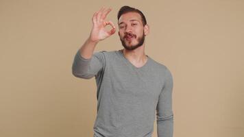 Ok. Joyful happy lebanese man in long sleeve looking approvingly at camera showing approve feedback gesture like sign positive something good. Handsome guy on beige background. People sincere emotion video