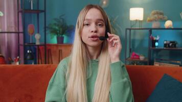 POV of Caucasian woman wearing headset, freelance worker, call center or support service operator helpline, having talk with client or colleague communication support waving hello. Girl at home room video