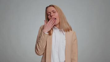 Tired business woman yawning, sleepy inattentive feeling somnolent lazy bored gaping suffering from lack of sleep. Adult girl isolated alone on gray studio background. Office people lifestyle concept video