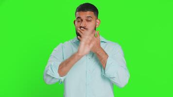 I will not say anything. Frightened man closing mouth with hands, looking intimidated scared at camera gestures no, refusing to tell terrible secret unbelievable truth. Guy on chroma key background video