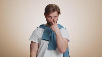 I am watching you. Young confident caucasian man pointing at his eyes and camera, show I am watching you gesture, spying on someone. Handsome bearded guy isolated alone on beige studio background video