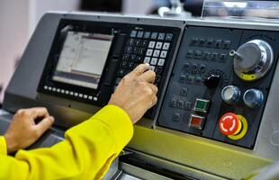 Machine operator hand turns on control panel of industrial machine. technician push button on control panel photo