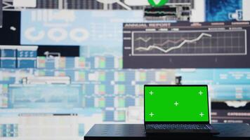 Empty business space has a laptop display with green screen, showcasing infographics and reports for decision making and strategy planning. Artificial intelligence data visualization. Camera B. video