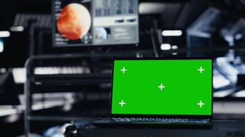 Green screen laptop in spacecraft used for data input next to nearby monitor showing Mars mission analysis. Mockup notebook assisting space station crew in managing planetary observations video