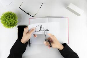 Overhead shot of hands cutting the word Chance on paper, symbolizing the elimination of risk and embracing new opportunities. photo