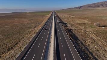 Aerial view of a car traveling on a highway surrounded by green fields video