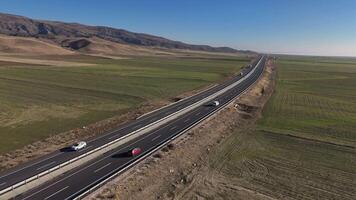 A vehicle drives down a sunny highway with green fields stretching endlessly video
