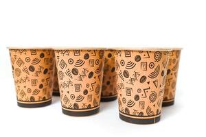 Group of patterned paper coffee cups arranged on a white surface, ready for a caffeine boost photo