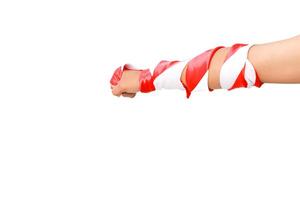 Isolated arm wrapped in red and white ribbon showcasing restricted movement and potential injury photo