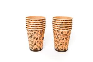 Two stacks of disposable coffee cups with brown Aztec pattern on a white background photo
