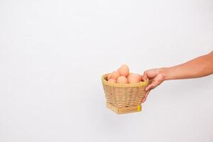 a person holding a basket full of eggs photo