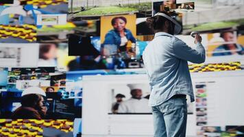 Young relaxed guy uses VR glasses for a 3d user interface design, showcasing AI connection for social media platforms. Male social network user working on entertainment in digital world. Camera B. video