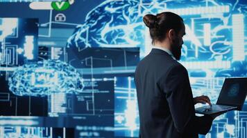 Young entrepreneur reviewing predictive analytics and machine learning algorithms. The digital interface reflects innovation, coding, AI ethics and platforms transformation. Camera B. video