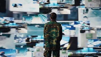 Male soldier showing respect and devotion with the military salute, monitoring satellite imagery for intelligence. Working on war planning tactics with battlefield details. Camera B. video