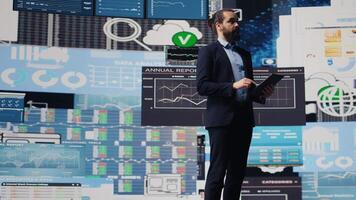 Surrounded by virtual graphs and forecasting models, chief executive officer uses financial data and insight to drive business growth. Ensuring performance and smart decision making. Camera B. video