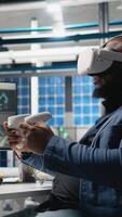 Vertical Black photovoltaics factory expert uses VR glasses to assembly digital solar cells, working with robotic arms for solar panels placement. Engineer uses machinery with virtual reality. Camera A. video