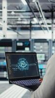 Vertical Software developer in data center uses AI technology on laptop to optimize storage volumes. IT expert in server hub facility using artificial intelligence to ensure seamless operations, camera A video