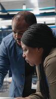 Vertical African american specialists supervisors examining production metrics on papers, supporting industrial innovation and alternative energy manufacturing process. Solar power. Camera A. video