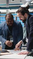 Vertical Multiethnic engineers industrial coworkers doing teamwork on production line for solar panels, combining technical insight and teamwork to drive forward clean energy infrastructure. Camera A. video