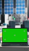 Vertical Futuristic solar panel production facility with copy space on empty desk, protective gear and laptop display shows photovoltaic performance. Manufacturing progress and automation. video