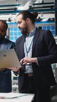 Vertical Team of diverse analysts consultants reviewing data and checklists in a high tech solar panel plant, ensuring manufacturing process meets sustainable energy and innovation standards. Camera A. video