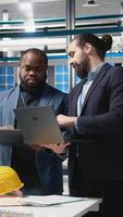 Vertical Multiethnic business associates and engineers gather for a discussion in a solar tech manufacturing facility, planning future developments in sustainable energy and industrial operations. Camera A. video
