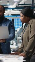 Vertical Black engineering professionals and directors review operational workflows in a solar manufacturing facility. Integrating teamwork in renewable energy production and development. Camera A. video