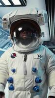 Vertical Scientist wearing helmet walking in cutting edge spaceship, doing cosmic voyage in solar system. African american astronaut wearing cosmonaut gear aboard orbital station, camera A video