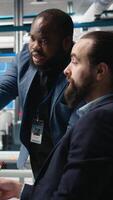 Vertical Factory supervisors diverse team sharing insight about production metrics, supporting industrial innovation and eco friendly clean energy development. Solar power improvement. Camera A. video