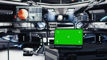 Mockup laptop in orbital station surrounded by high tech displays tracking Mars telemetry. Green screen notebook enabling real time mission control and spacecraft status updates video