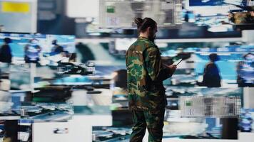 Army officer working in a virtual war zone with digital tech and satellite data, using threat detection tools for national safety. Modern military strategy to ensure control in a mission. Camera B. video