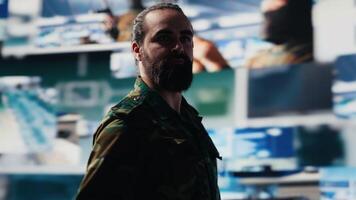 Professional soldier ensures real time intelligence from control center hub, analyzing data collected from satellite imagery. National defense operations with surveillance. Camera A. video