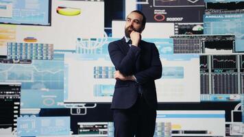 Businessman thinking about a new solution to increase funding while he evaluates infographics and financial reports with digital technology. Planning long term success and growth. Camera B. video