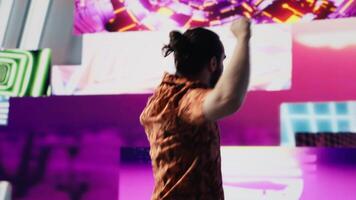 Cool digital content creator dancing under glowing neon lights, expressing rhythm and individuality. Surrounded by groovy music and artistic visuals, bringing energy and retro style. Camera A. video